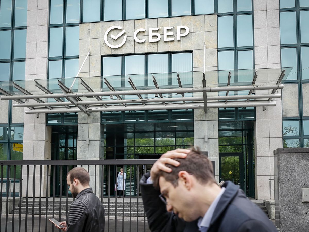 Foto: Ciudadanos caminan frente a la sede de Sberbank en Moscú. (EFE/Yuri Kochetkov)