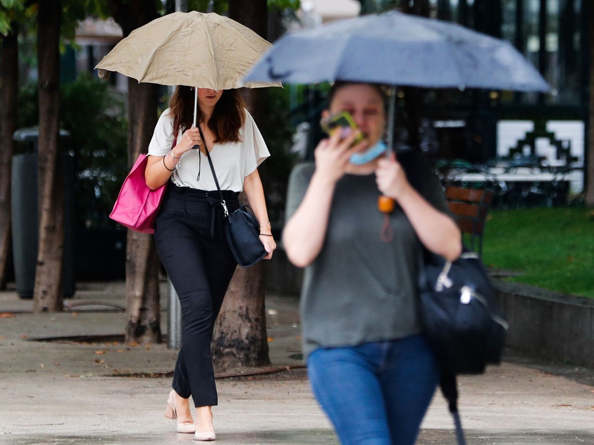 Foto: Dos personas caminan con paraguas en una imagen de archivo. (EFE/Luis Millán)