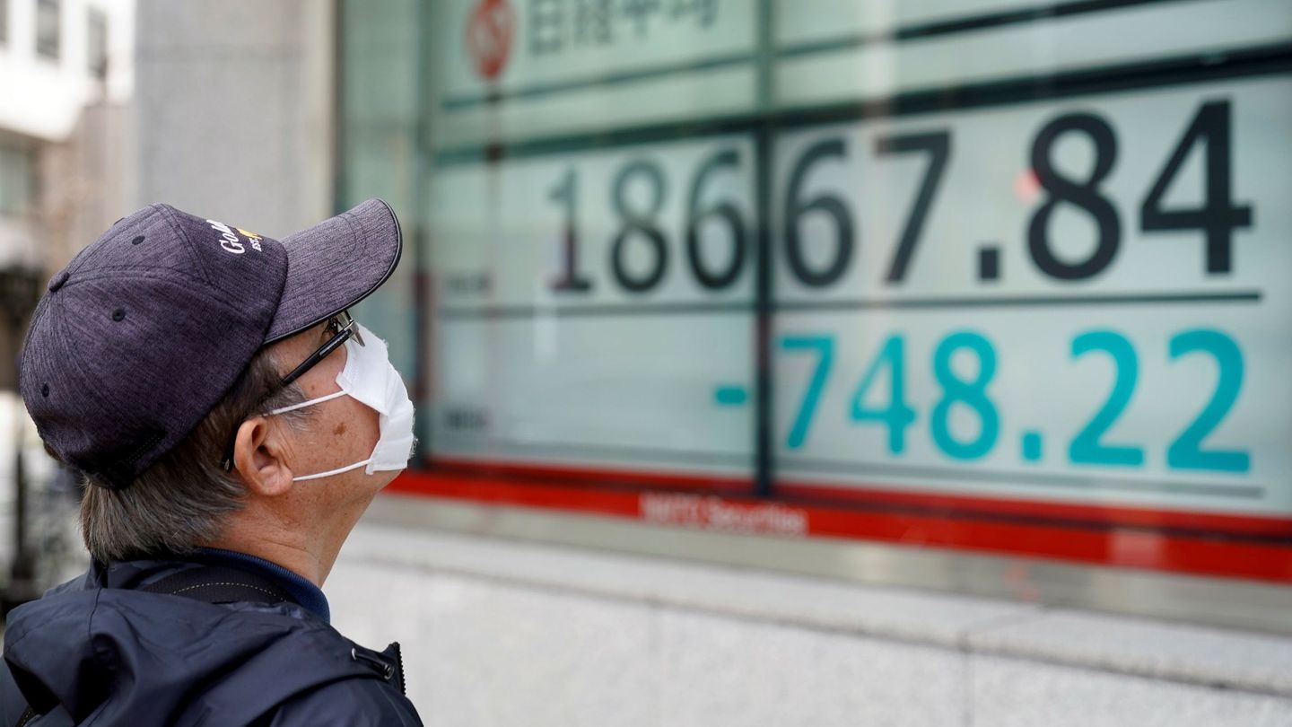 Un ciudadano que lleva mascarilla observa los índices junto a la sede de la Bolsa de Valores de Tokio (TSE) (Japón). (EFE)