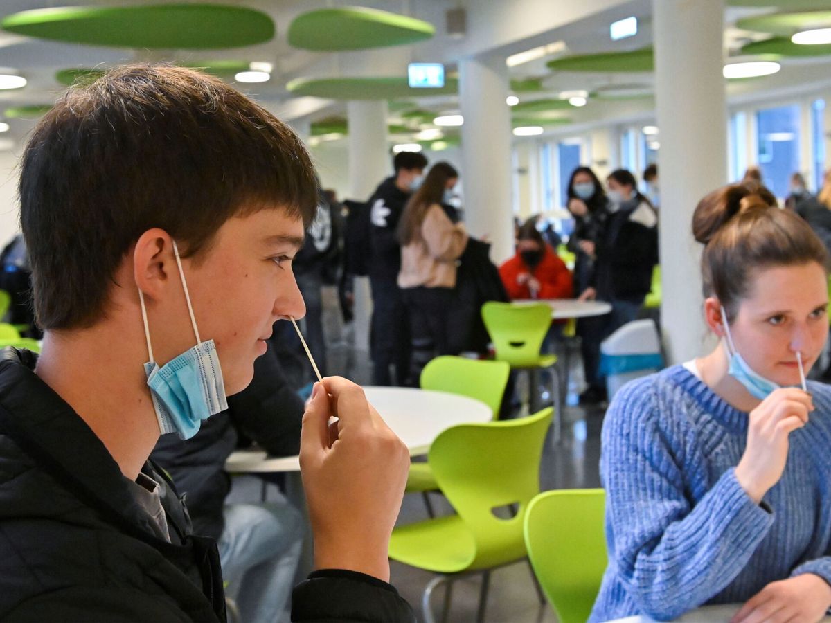 Foto: Dos estudiantes haciéndose un test de coronavirus. (Reuters/Matthias Rietschel)