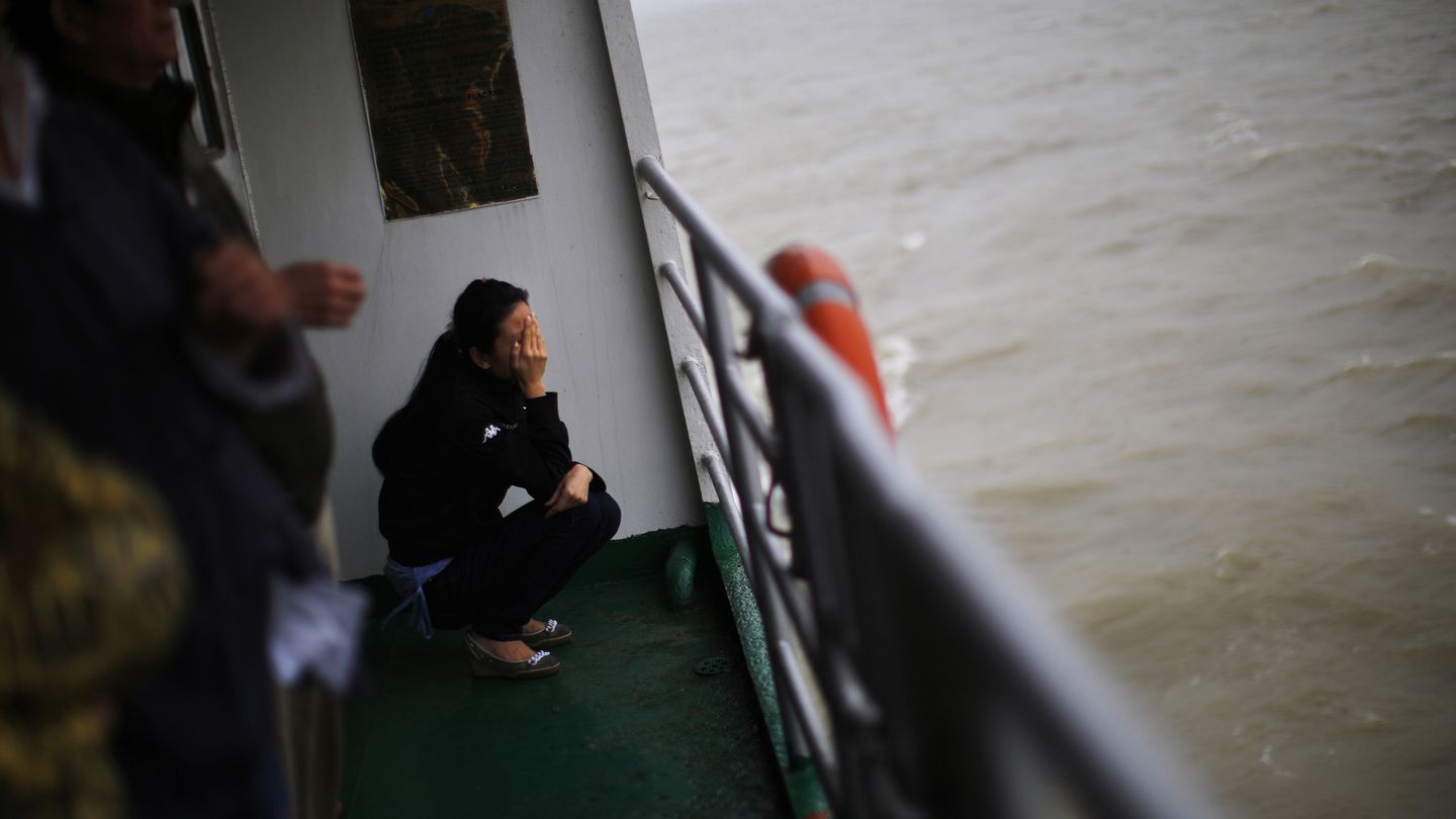 Una mujer llora durante un entierro en el mar en Shanghái, China (Reuters).