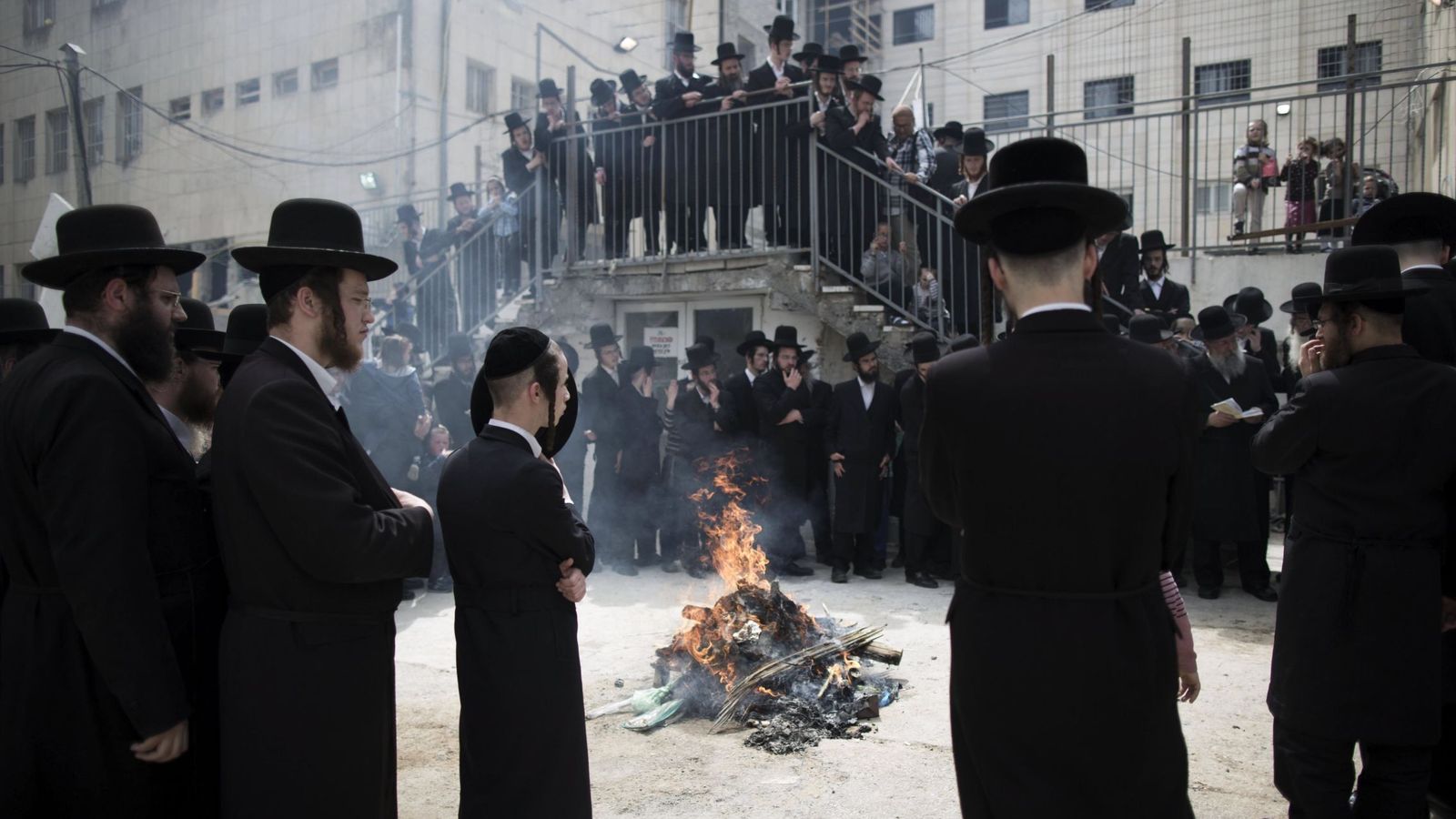Foto: Varios judíos ultraortodoxos rezan mientras se procede a la quema de pan con levadura en el barrio de Mea Shearim en Jerusalén. (EFE)