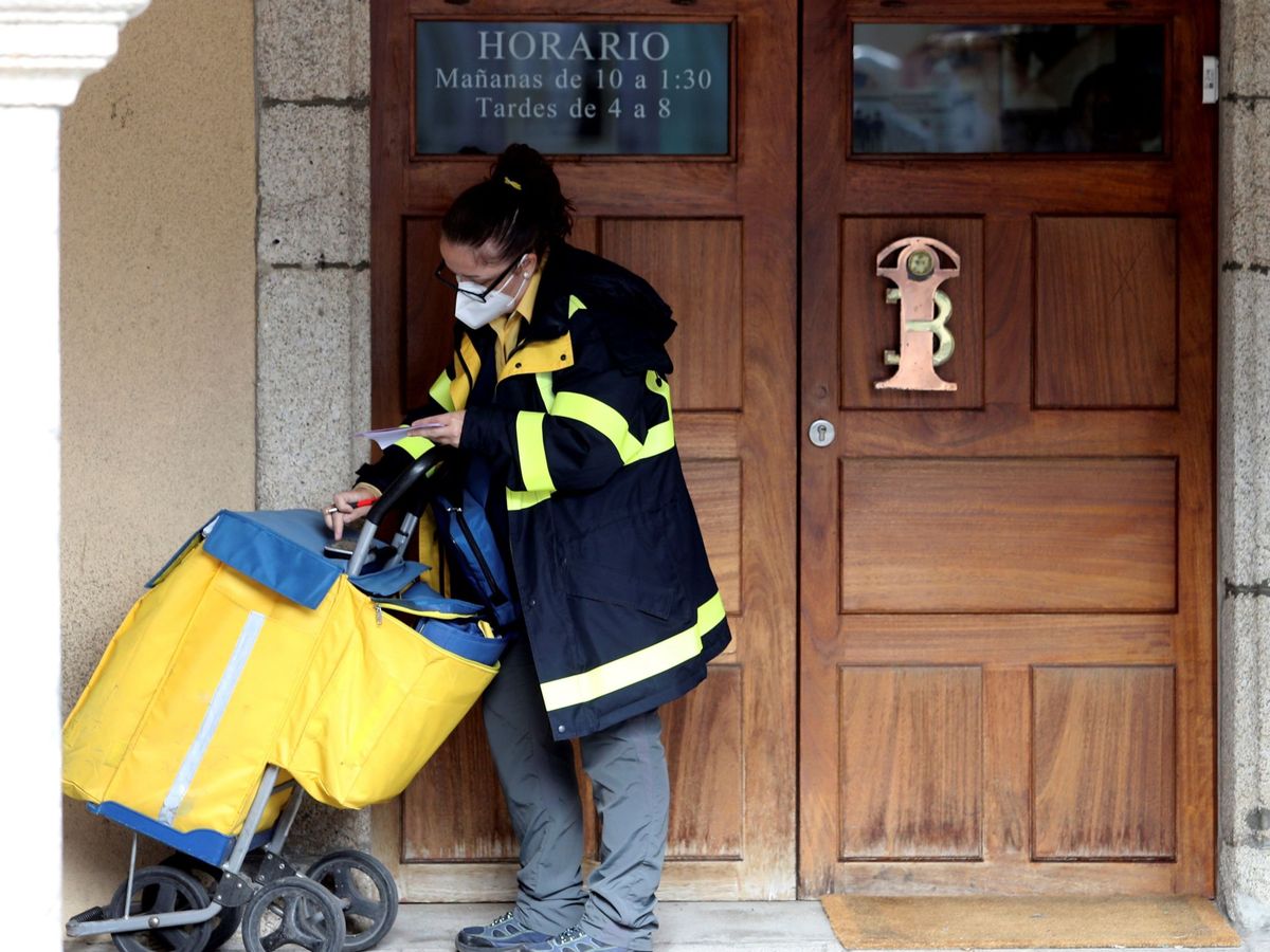 Foto: Una trabajadora de Correos entrega cartas en un edificio de Ponferrada, León. (EFE)