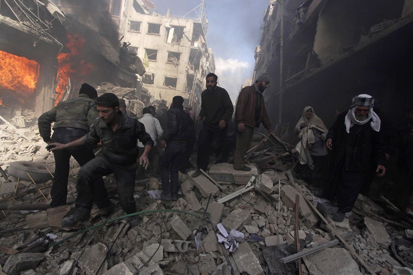 Civiles sirios caminan sobre los escombros tras ataques aéreos del régimen en Duma. (Reuters)
