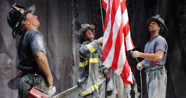 Foto: Un grupo de bomberos sostiene una bandera estadounidense durante el 11-S. (Reuters)