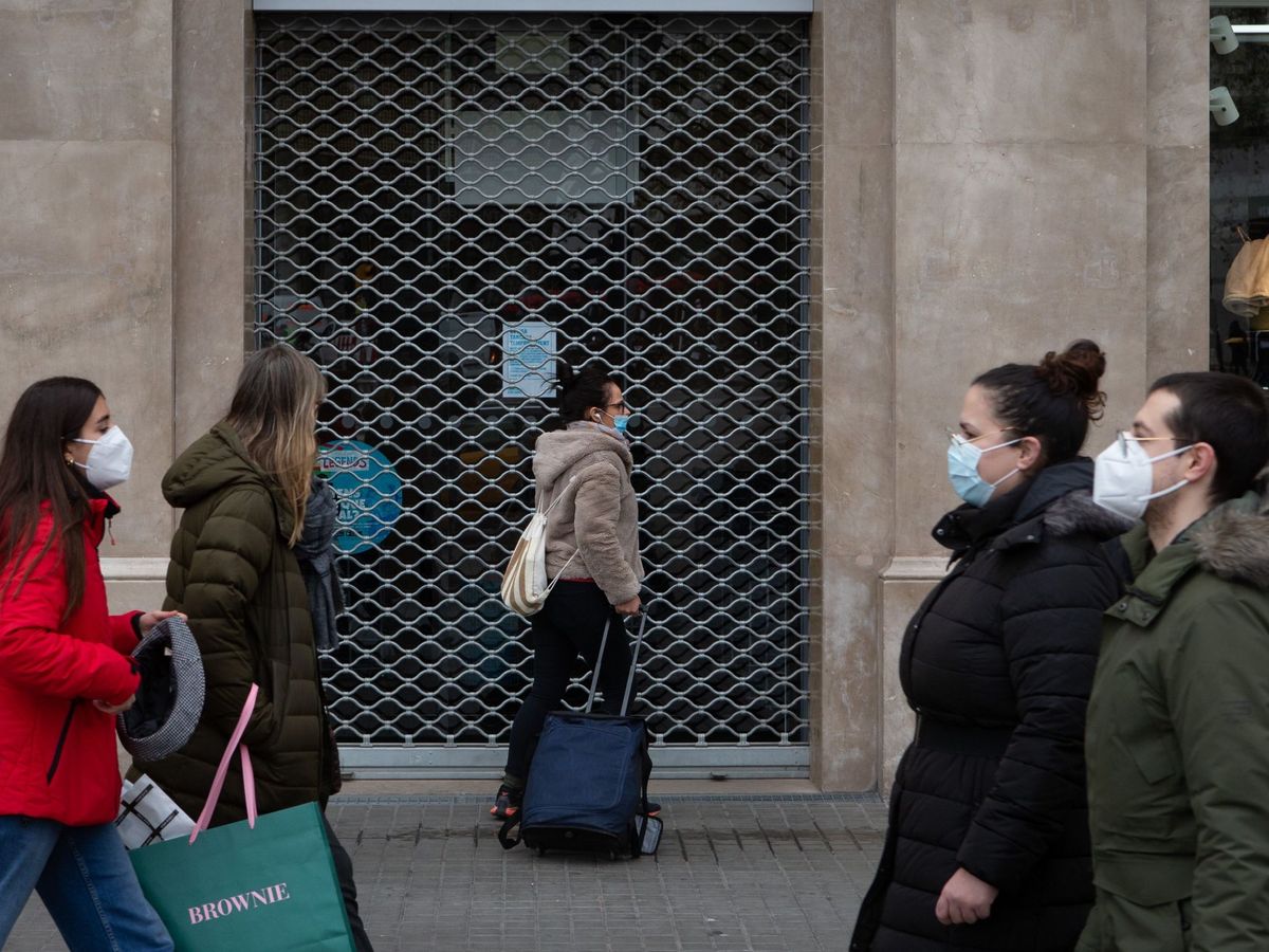 Foto:  Varios transeúntes pasan ante un comercio del centro de Barcelona. (EFE)