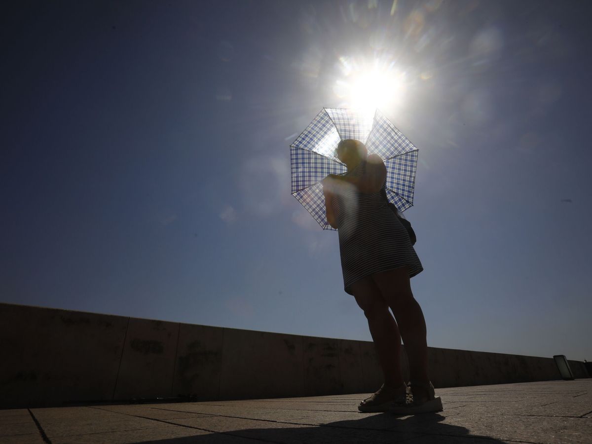 Foto: Una mujer se protege del sol con un paraguas en Córdoba. (EFE/ Salas)