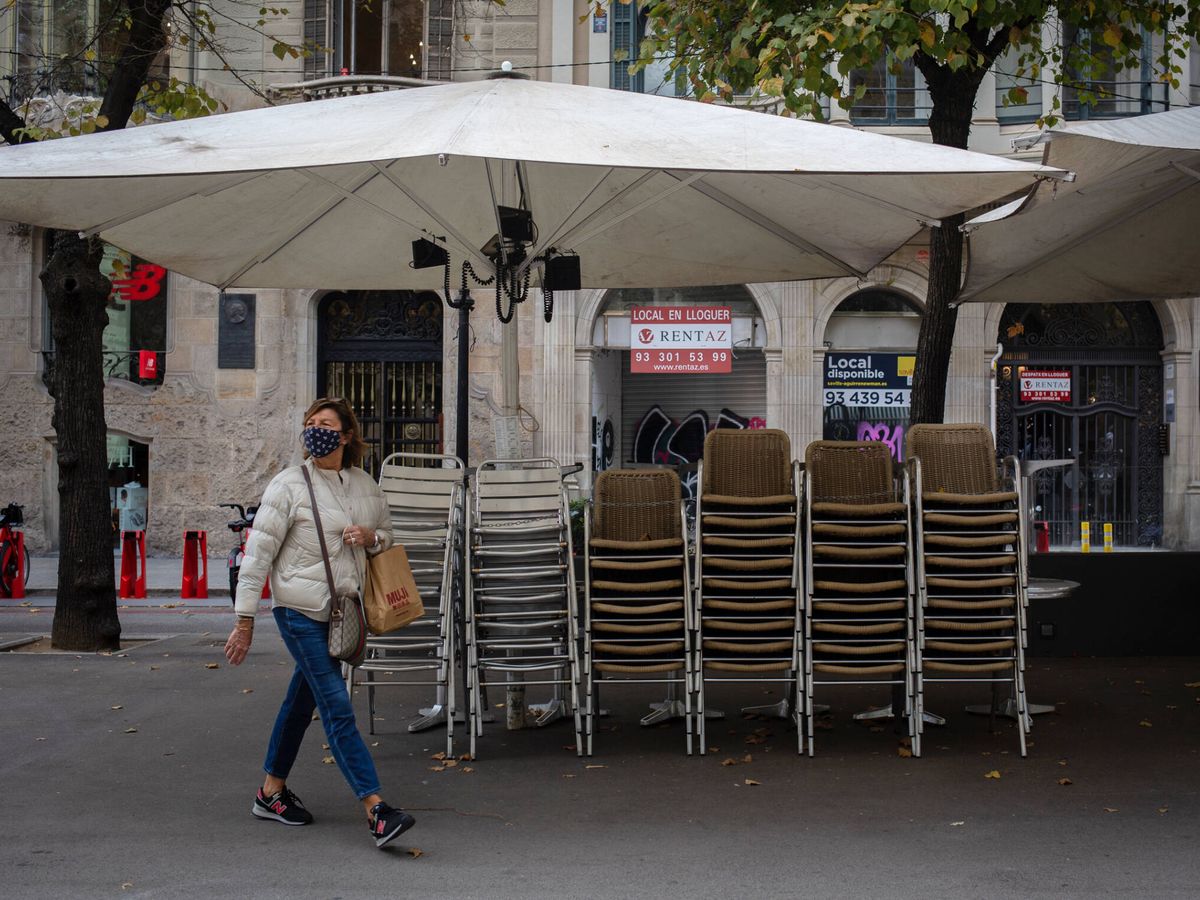Foto: Una mujer pasa junto a la terraza de un bar cerrado por las restricciones en Barcelona en octubre de 2020. (Europa Press/David Zorrakino)
