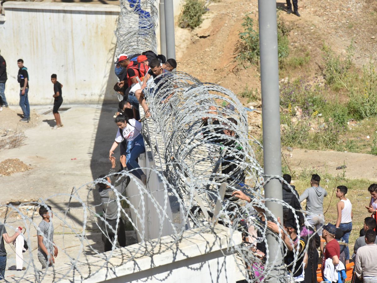 Foto: Inmigrantes saltan la valla entre Marruecos y Ceuta. (EFE)