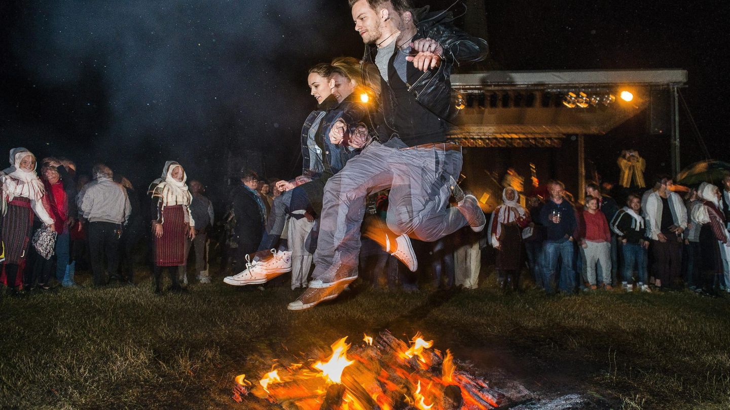 Una pareja salta sobre una hoguera durante la noche de San Juan en Hungría | EFE