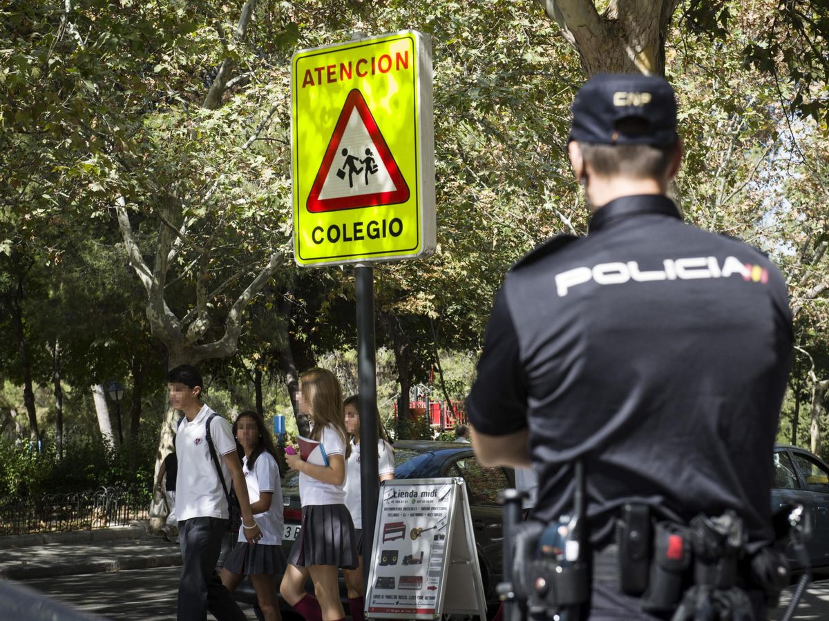 Foto: Agentes de la Policía Nacional vigilan la salida de un colegio en el distrito madrileño de Ciudad Lineal, el mismo distrito donde han agredido a una joven de 12 años. (EFE/Luca Piergiovanni)