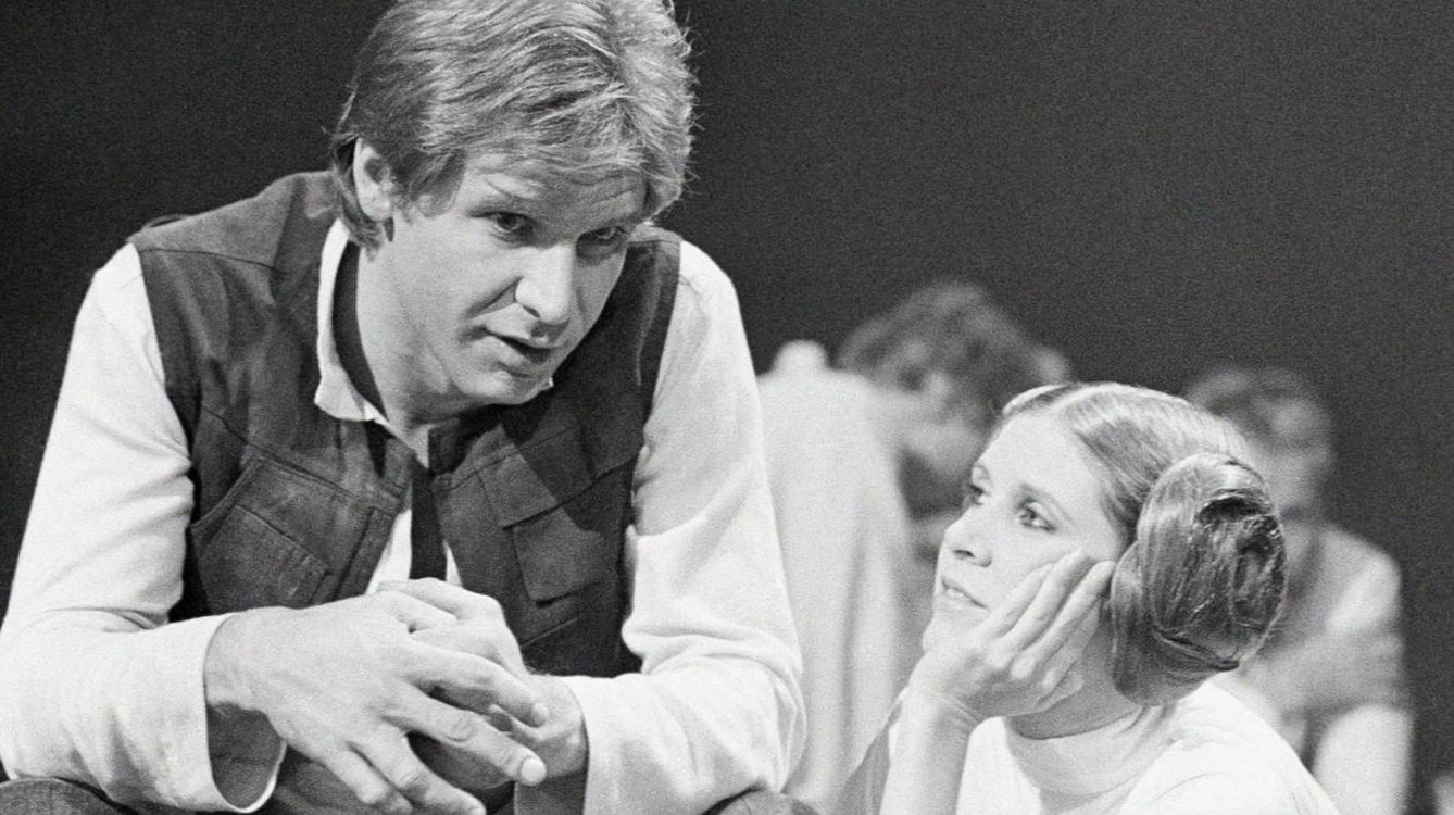 Carrie Fisher mira con devoción a su compañero de pareja y amante Harrison Ford
