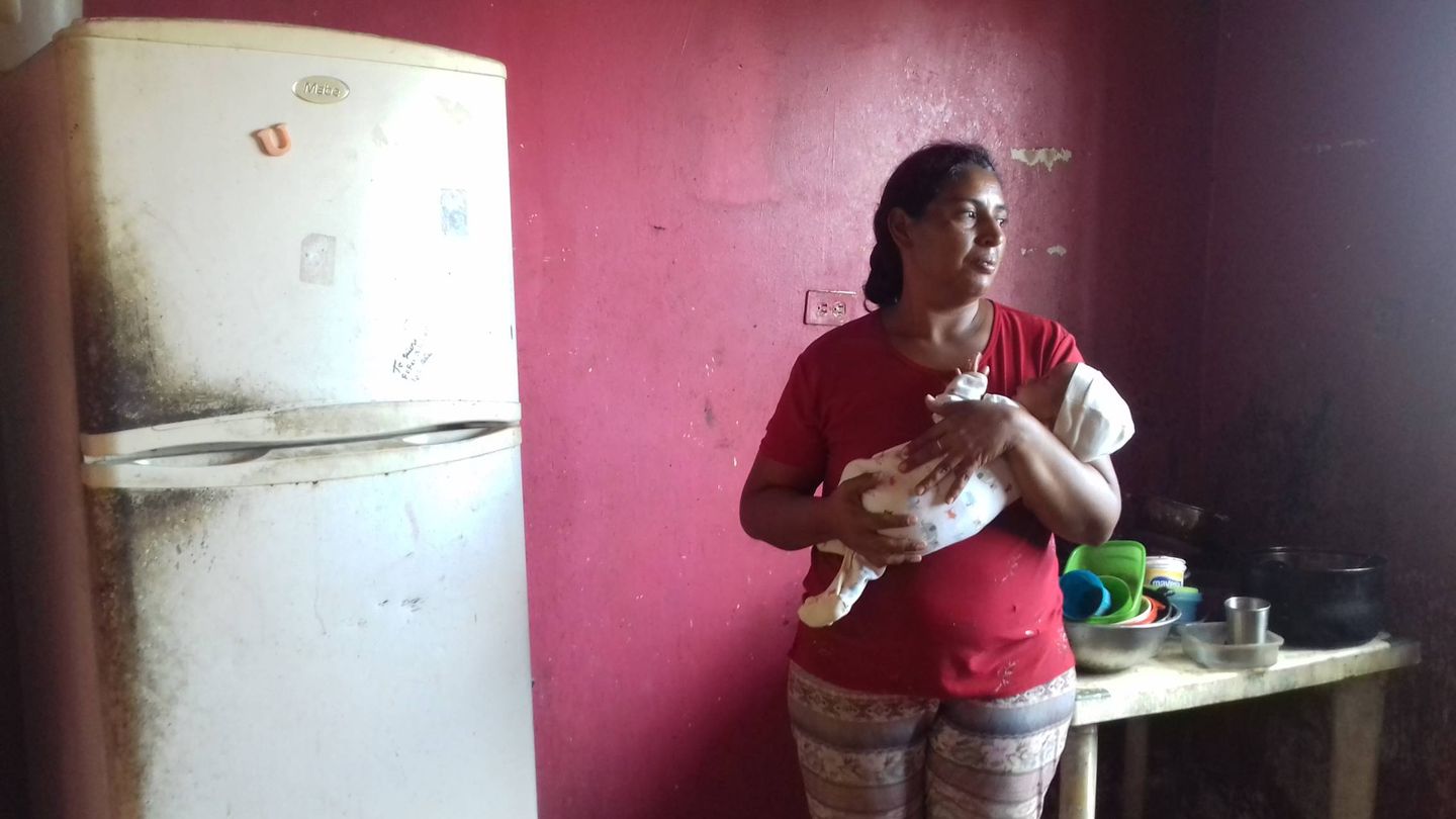 La abuela de Joandry lo sostiene en sus brazos en la cocina de su casa. (M. Á. Ramírez Cabello)