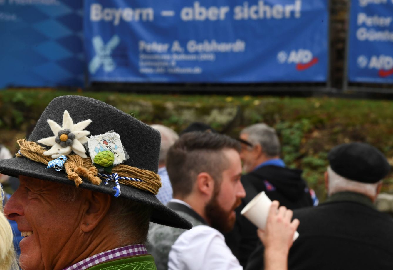 Alemanes durante el festival Gillamoos, en Abensberg. Al fondo, un cartel electoral de AfD. (Reuters)