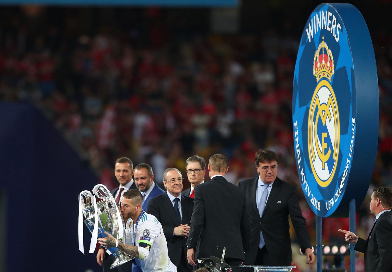 Sergio Ramos besa el trofeo de la Champions. Detras, Florentino Pérez, con las manos cruzadas. (EFE)