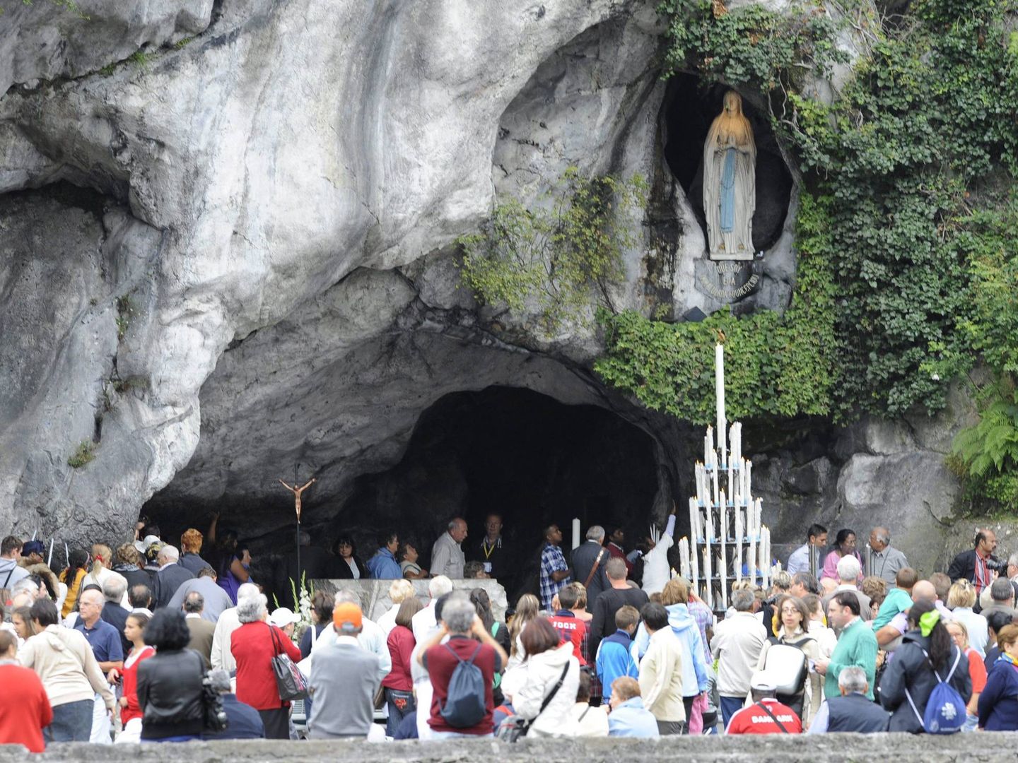 Peregrinos visitan la gruta en la que se apareció ante Bernadette Soubirous la Virgen (EFE)