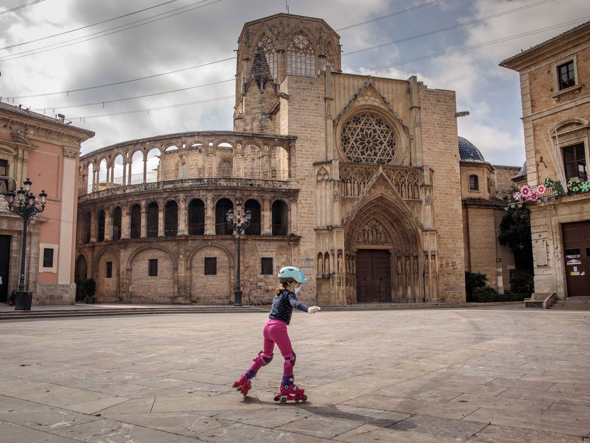 Foto: Una niña patina en una vacía plaza de la Virgen de Valencia. (EFE)