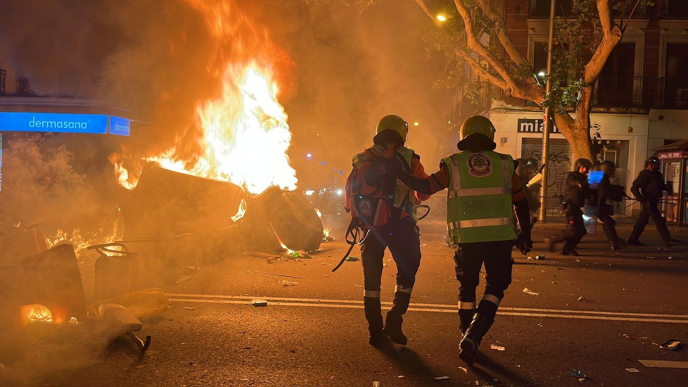 Foto: Los bomberos tratan de sofocar un fuego provocado por los radicales en la parada de Metro de Argüelles. (Foto: A. Farnós)