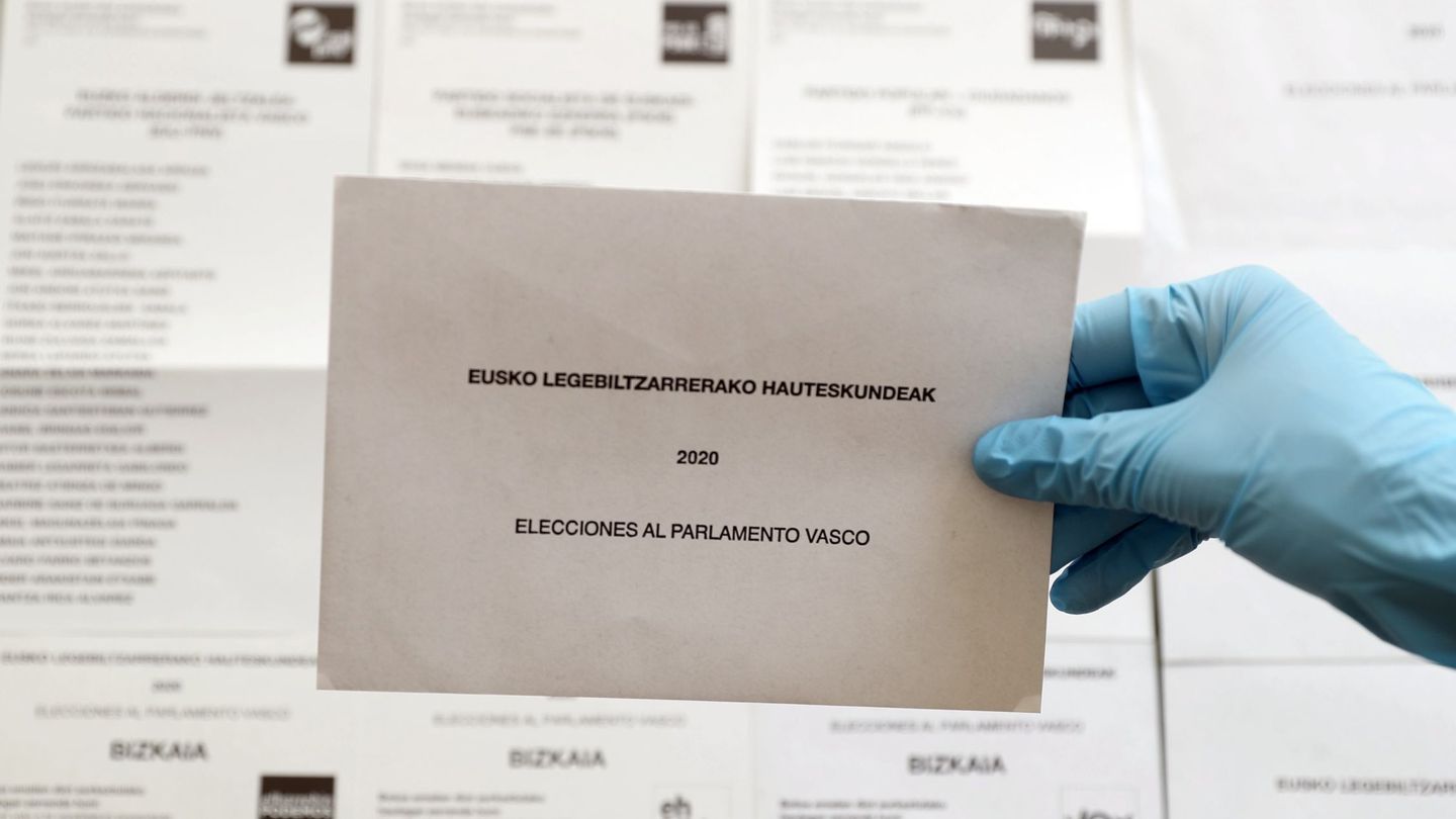 Un sobre para depositar el voto junto a diferentes opciones políticas al Parlamento Vasco. (EFE)