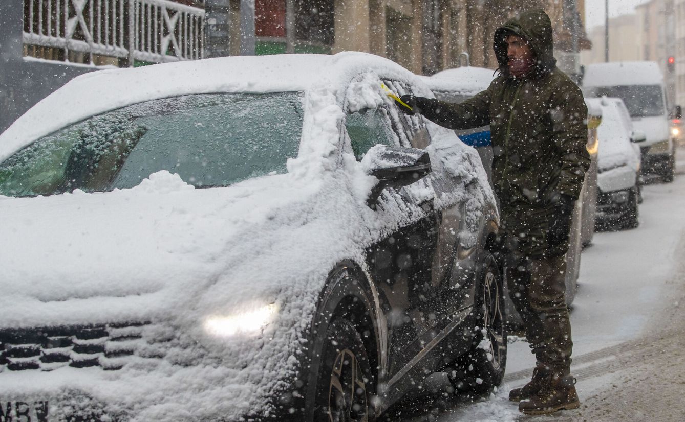 Un chico quitando nieve de su coche en Soria. (EFE)