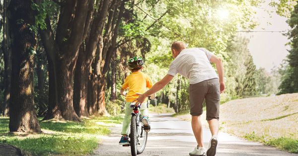 Foto: Un padre enseña a montar en bicicleta a su hijo. (iStock)
