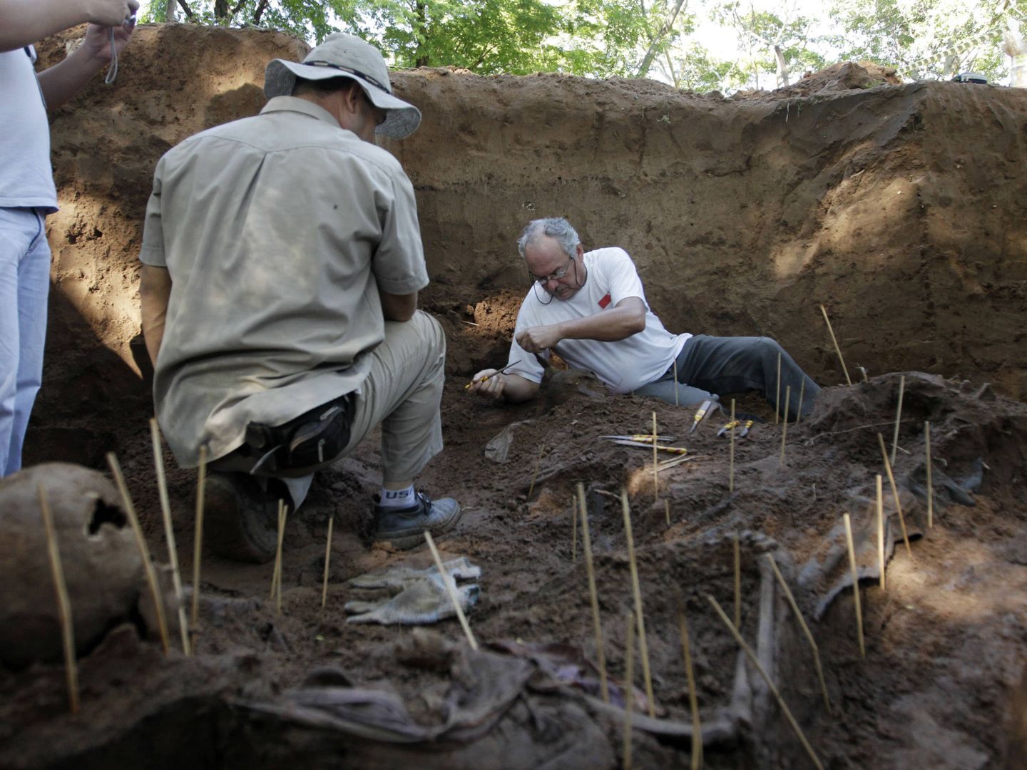 Forenses trabajan con restos humanos descubiertos bajo unas barracas de la policía en Asunción. (Reuters) 