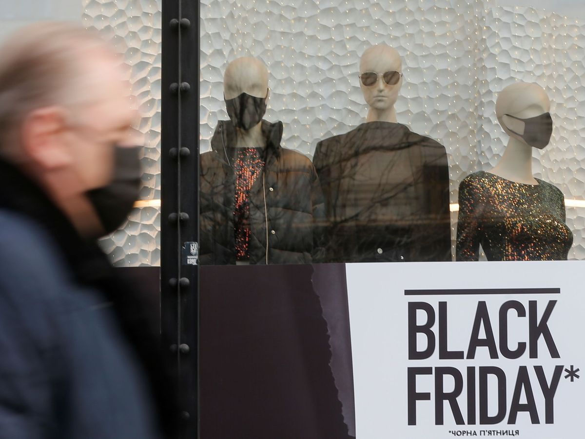 Foto: Un viandante pasa junto a un escaparate con un anuncio del Black Friday. (Reuters/Valentyn Ogirenko)