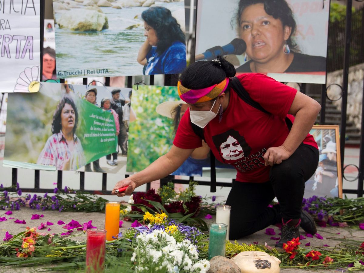 Foto: Una integrante del Consejo Cívico de Organizaciones Populares e Indígenas de Honduras (COPINH) enciende una vela junto a la foto de Berta Cáceres. (EFE)