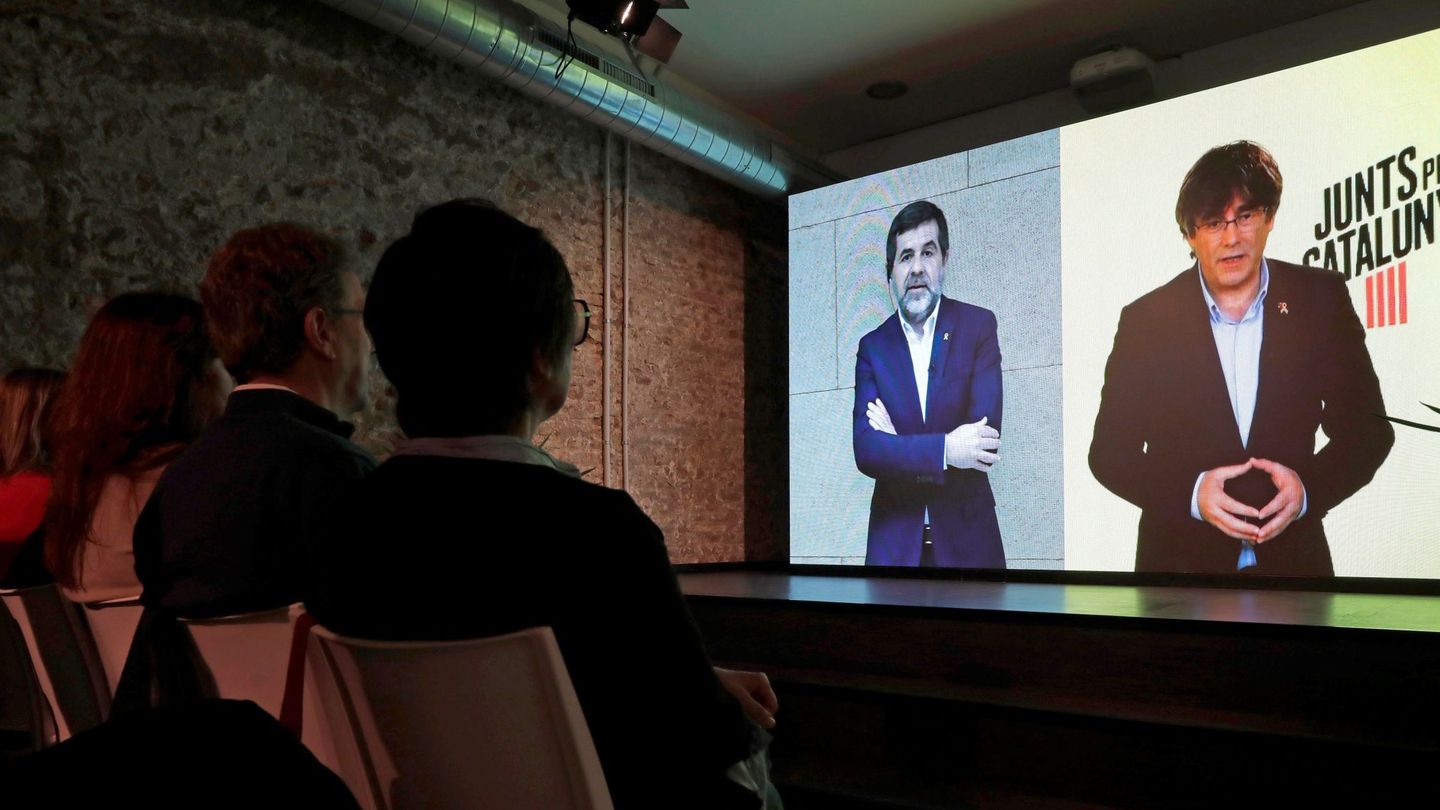 El 'expresident' Puigdemont (d) y Jordi Sànchez (i) en conversación por videoconferencia en la sede electoral de JxCAT. (EFE)
