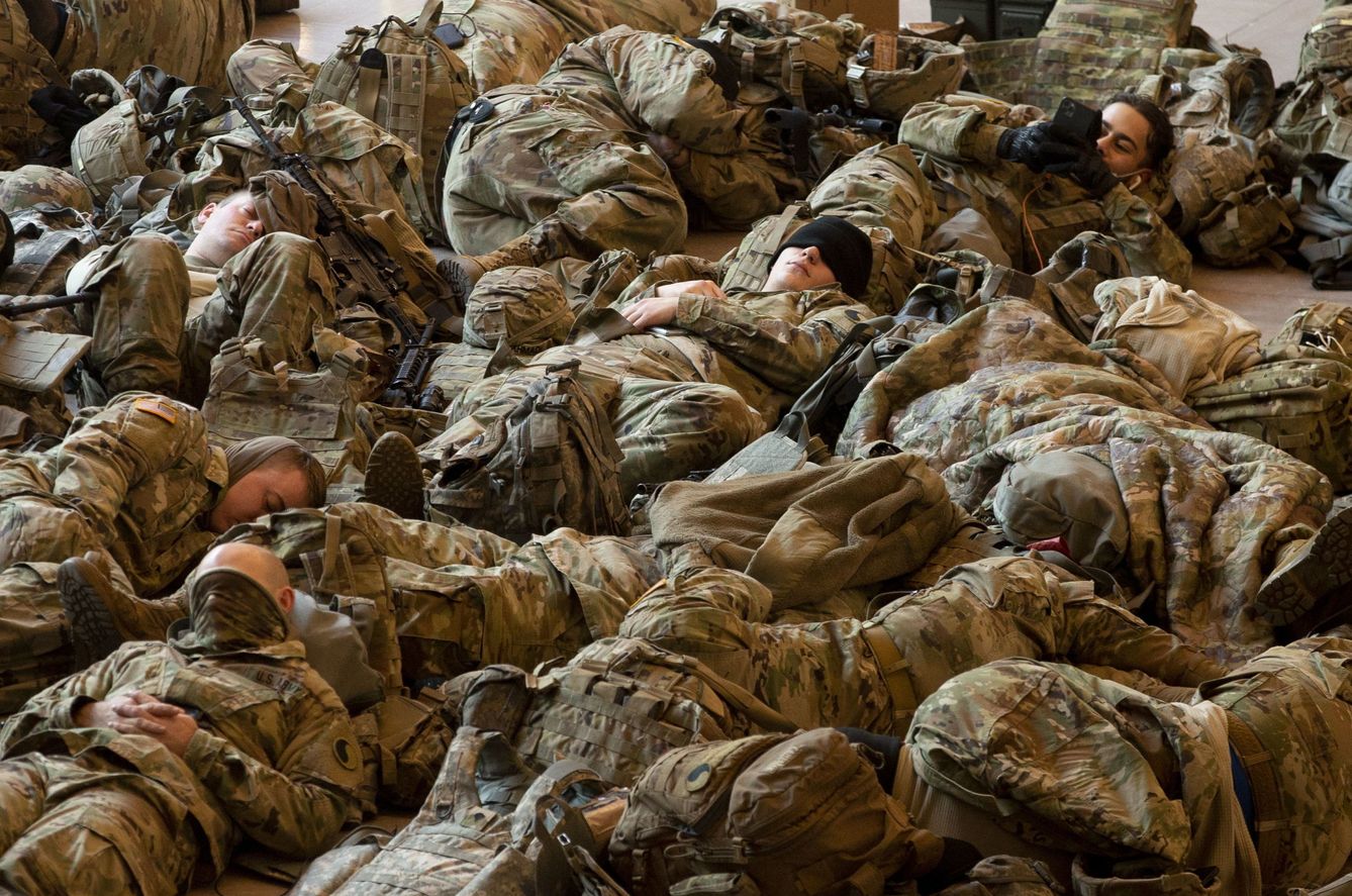 Miembros de la Guardia Nacional descansan en el edificio del Capitolio. (Foto: EFE)