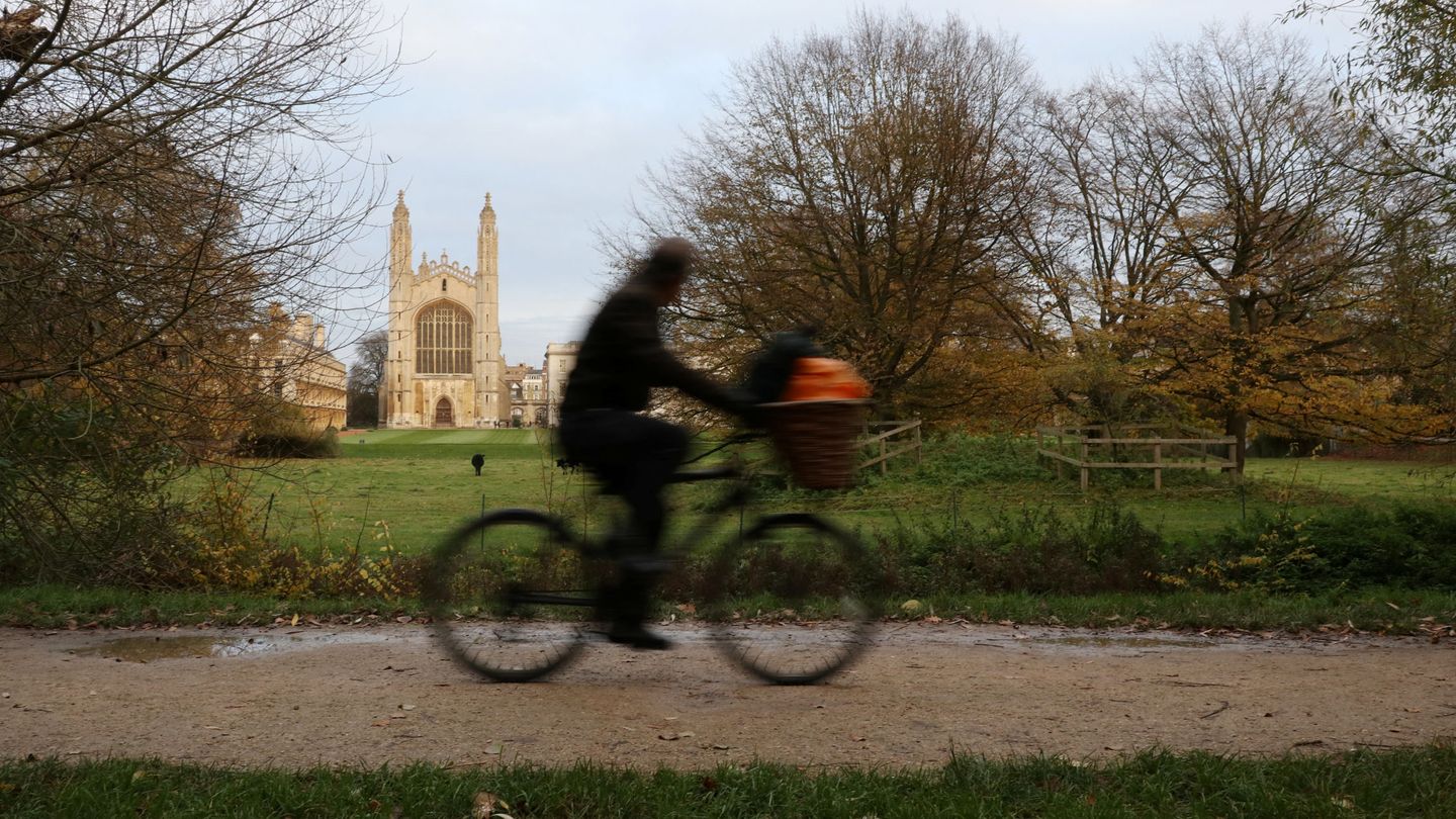 Un ciclista pasea por los alrededores de Cambridge con el King's College de fondo, uno de los pocos colegios no involucrados en las inversiones.