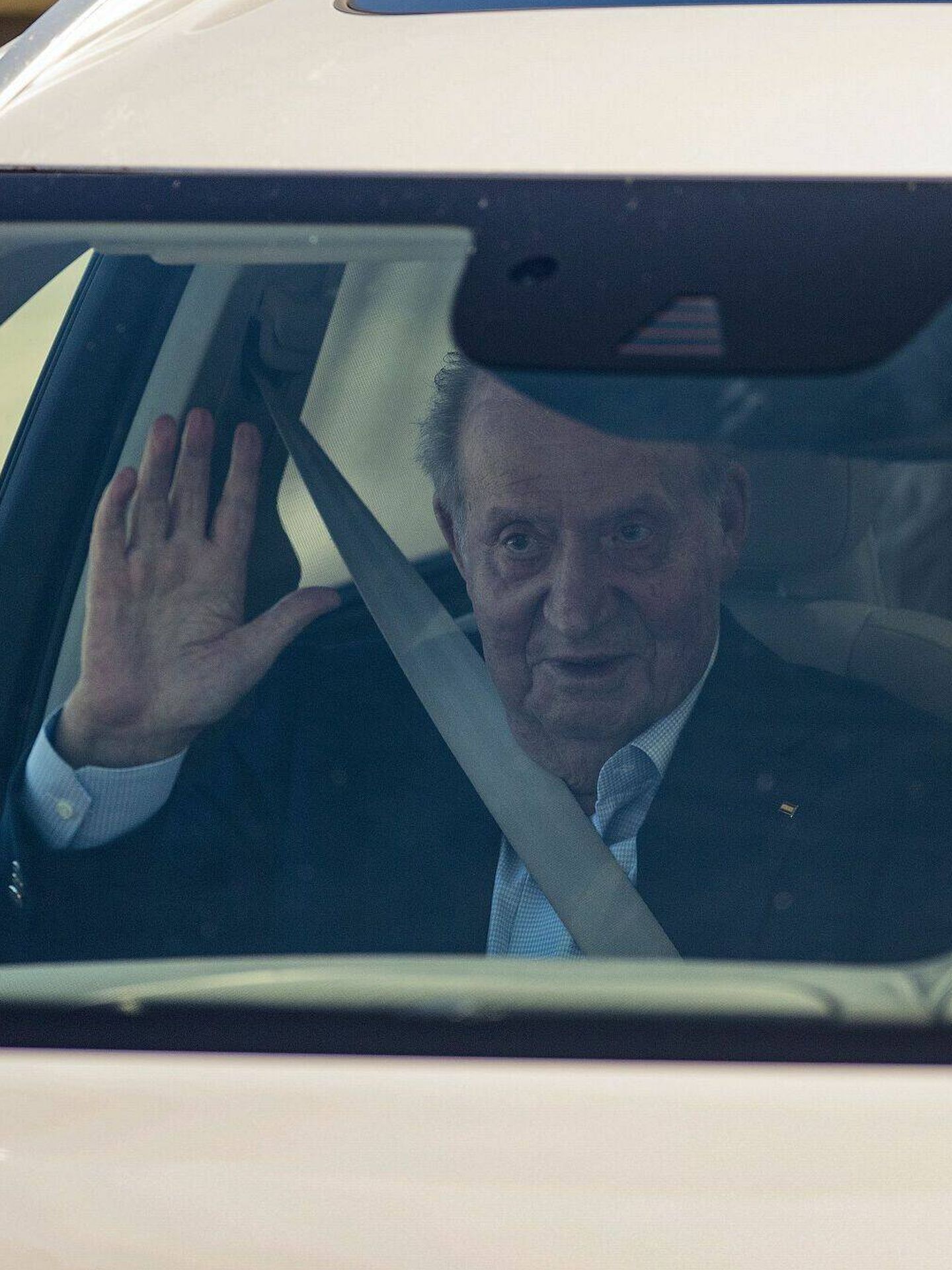 El rey Juan Carlos, saludando desde el interior del coche. (EFE)