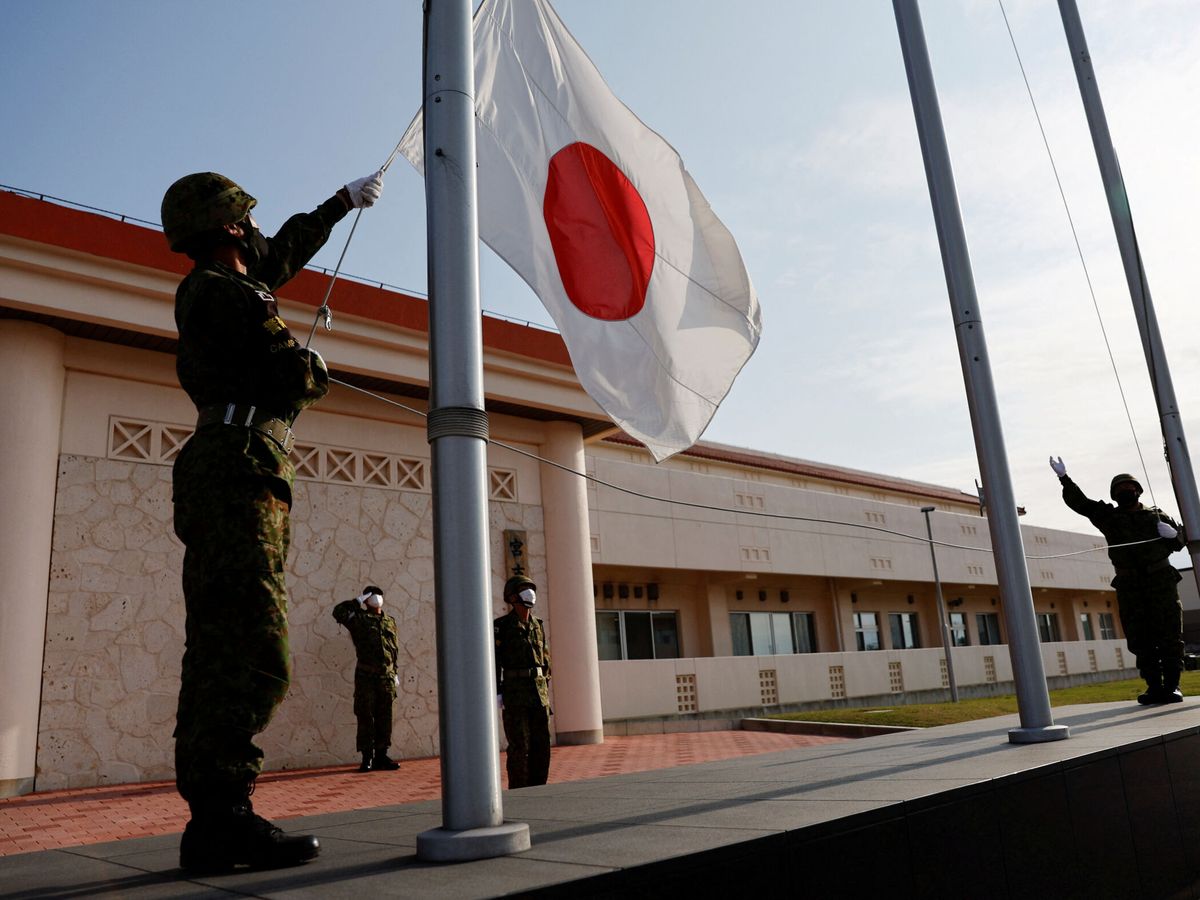 Foto: Un soldado japonés arría la bandera con la llegada del atardecer. (Reuters/Issei Kato)