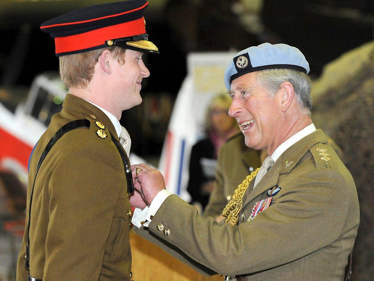 Foto: El príncipe Harry recibe la acreditación de piloto de manos de su padre. (EFE/Richard Dawson))