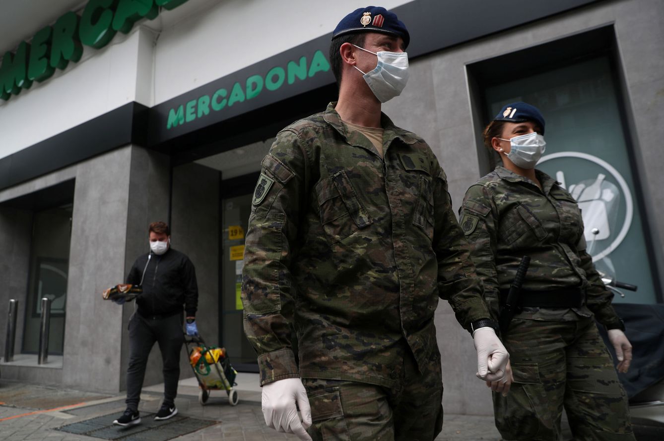 Miembros de la Guardia Real pasan frente a un Mercadona. (Reuters)