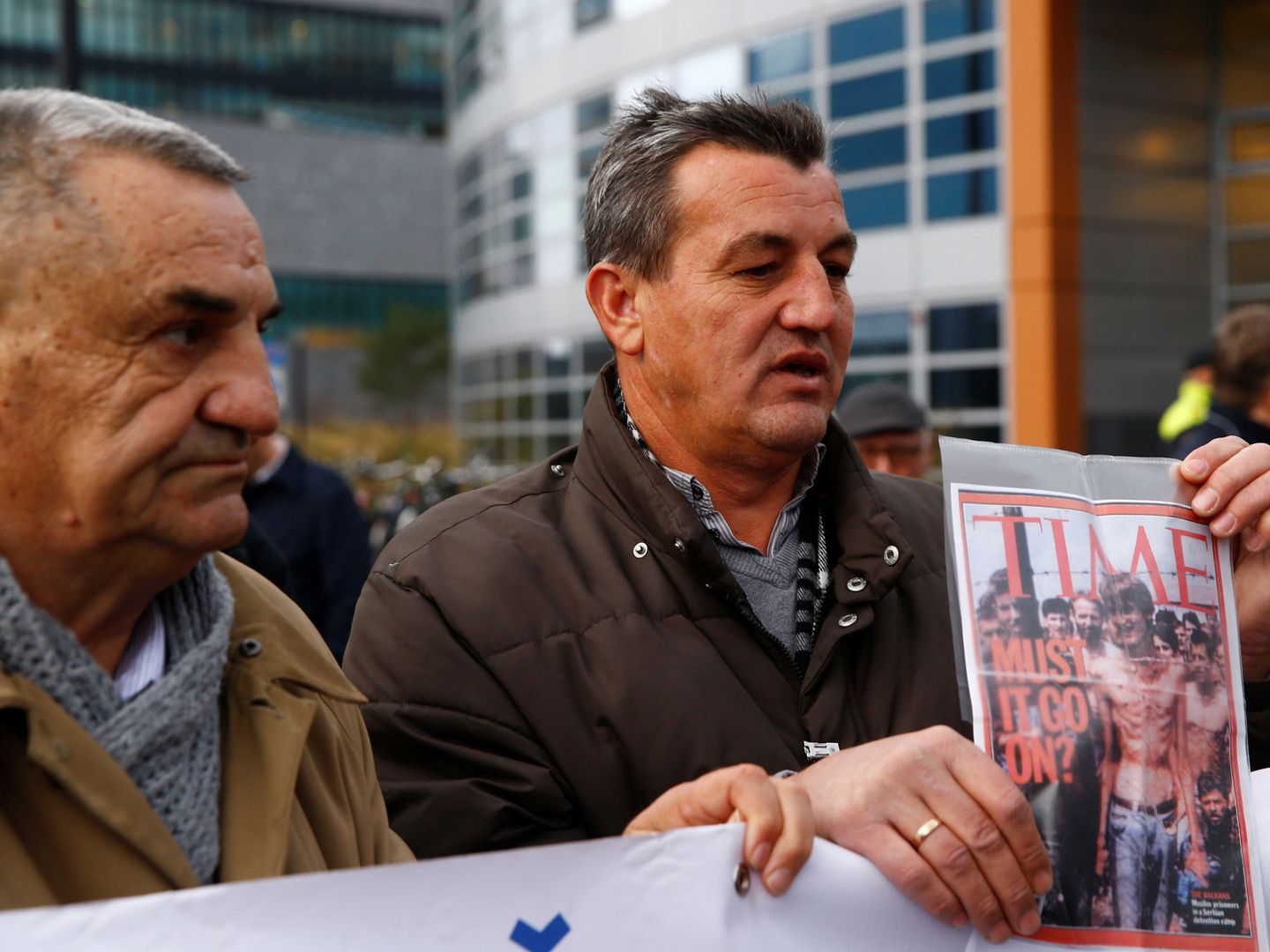Fikret Alic enseña su foto en la portada de la revista Time antes del juicio a Ratko Mladic (Reuters)