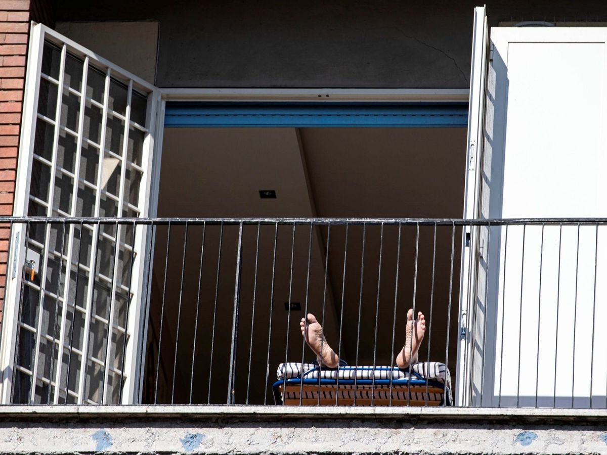 Foto: Un hombre, tumbado en su balcón. (EFE)