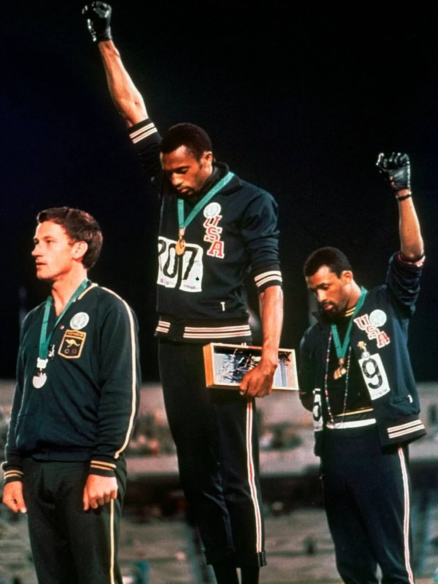 Tommy Smith y John Carlos, con el puño en alto, en el podio de los 200 metros lisos en los Juegos Olímpicos de 1968.
