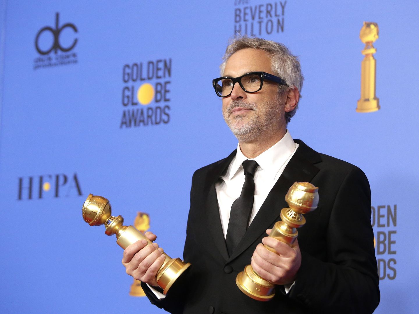 Alfonso Cuarón con sus dos globos de oro. (Efe)