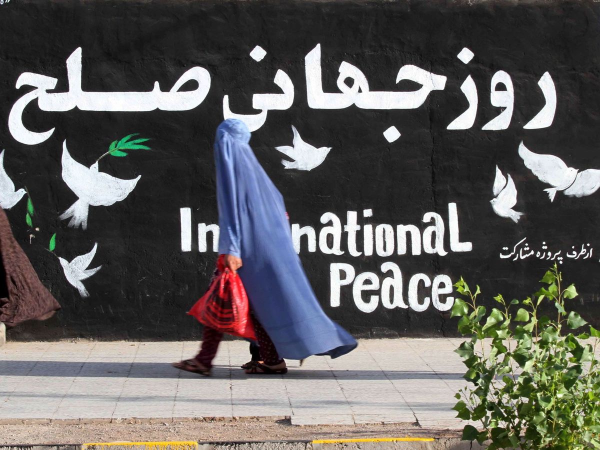 Foto: Una mujer frente a un mural en Herat, Afganistán. (EFE)