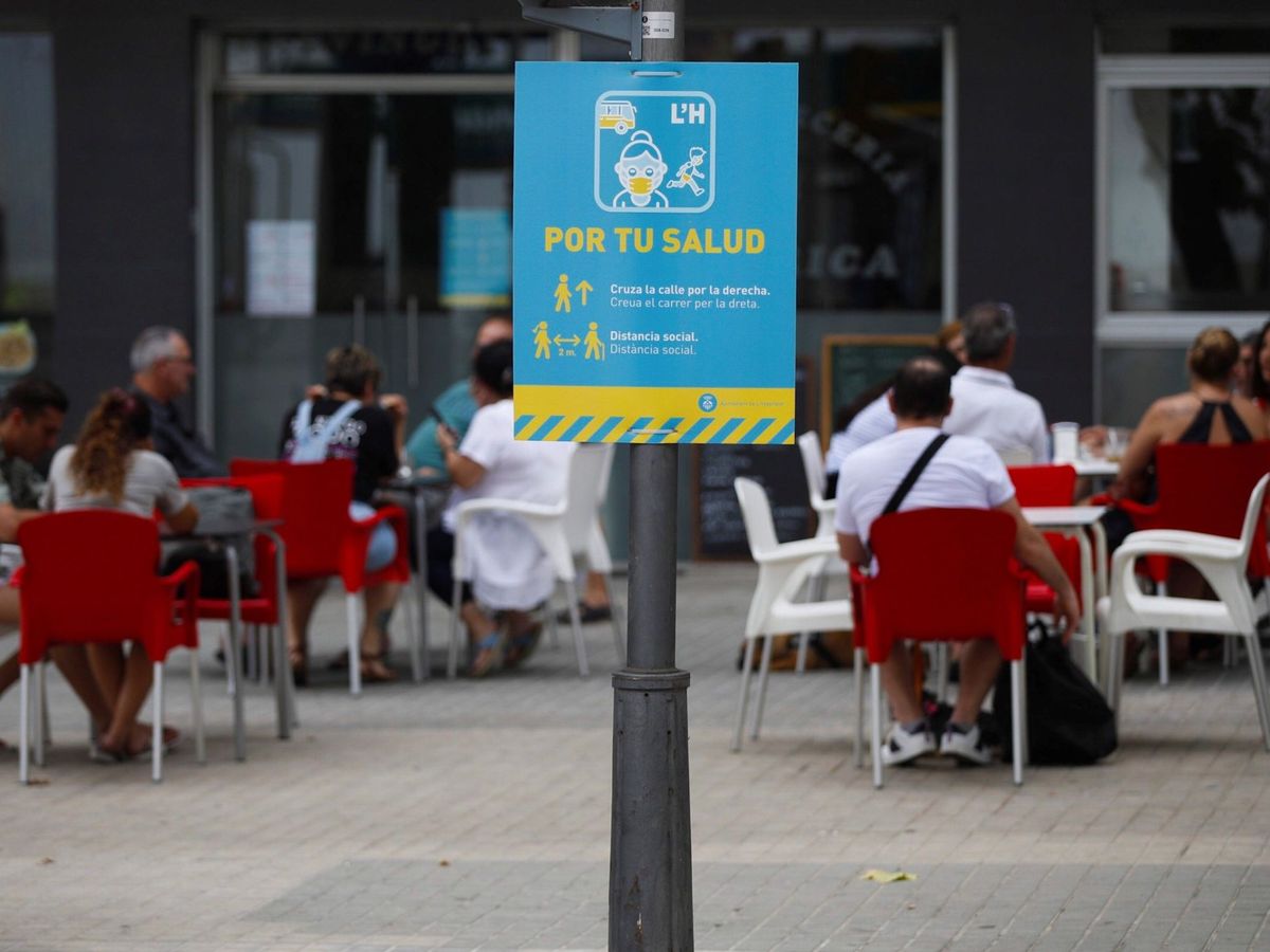 Foto:  Un cartel informa de la obligatoriedad de usar mascarilla en una calle en L'Hospitalet. (EFE)