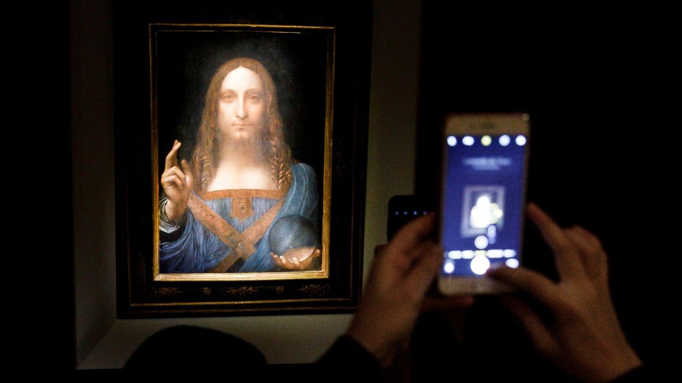 Foto: Una persona toma una foto del 'Salvator Mundi' el 15 de noviembre de 2017, antes de que la obra fuera subastada por 450 millones de dólares en Christies. (EFE)