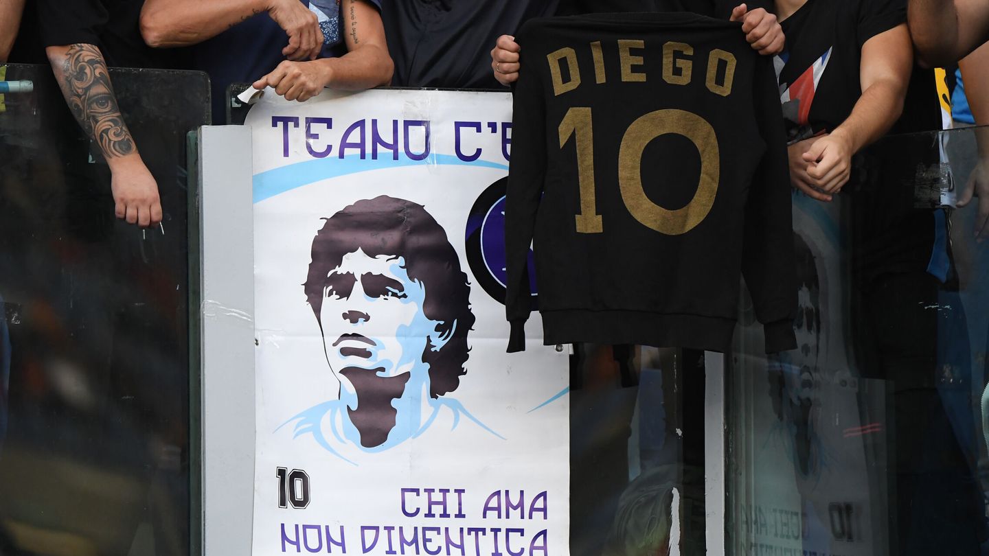Camisetas y pancartas de Maradona en los partidos que juega el Nápoles. (Efe)