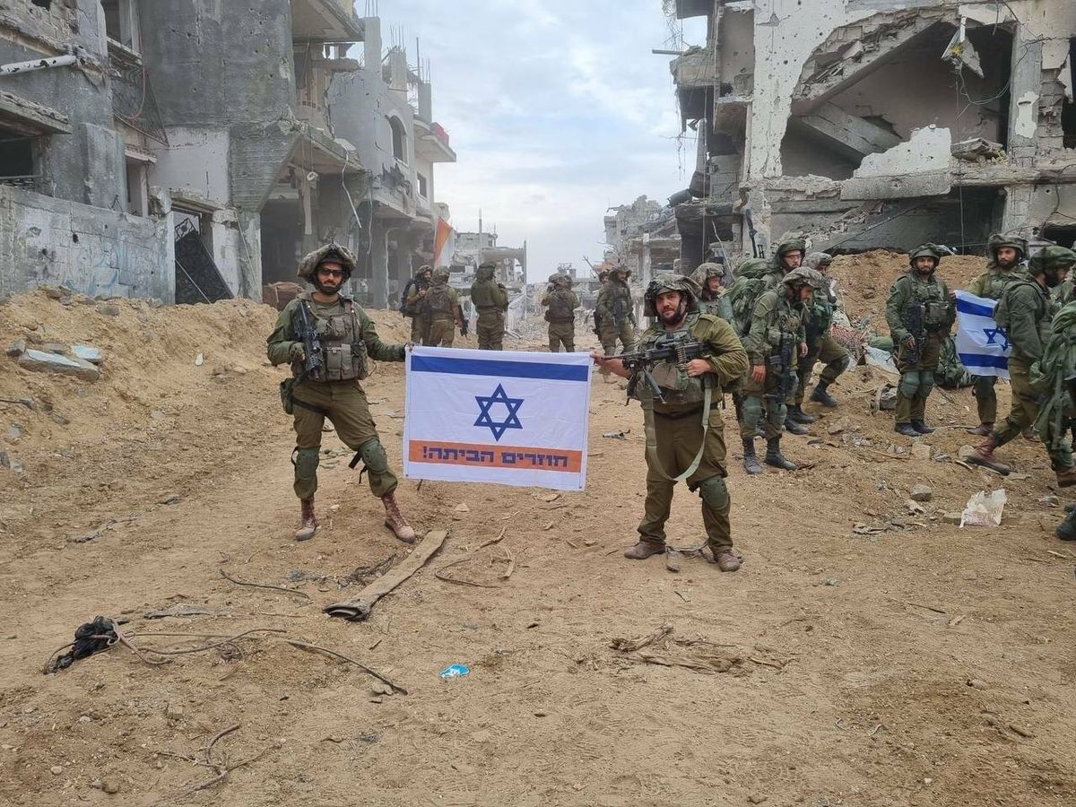Foto: Soldados israelíes desplegados en Gaza sostienen una bandera con el mensaje "Volviendo a casa". (IDF/Twitter)