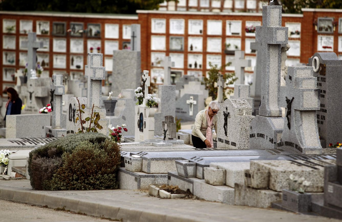 Una mujer limpia una tumba en el madrileño cementerio de La Almudena. (EFE)