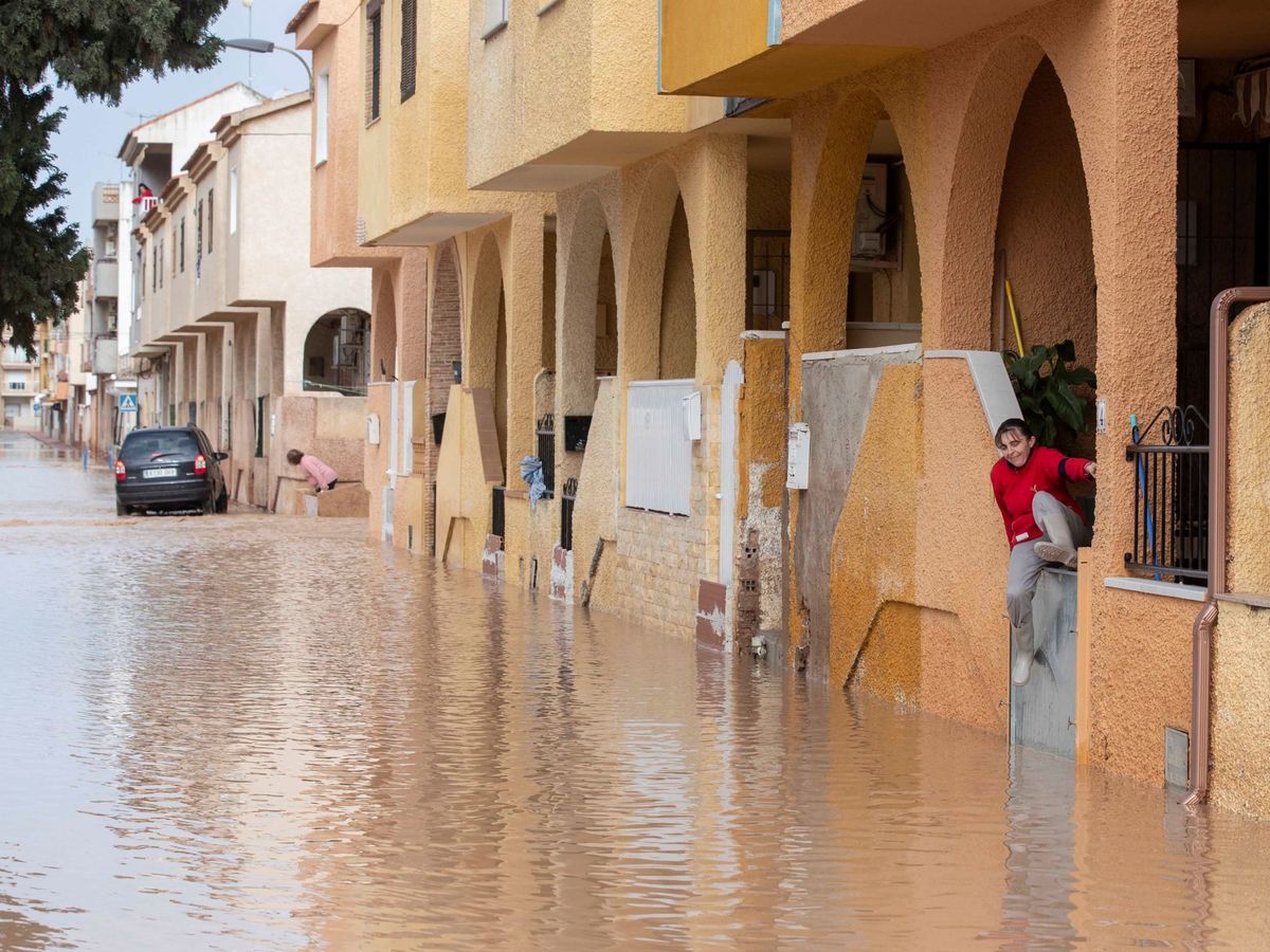 Foto: Una mujer intenta salir de su casa a la calle inundada, el martes 21, en el municipio de Los Alcázares, Murcia. (Marcial Guillén / EFE)