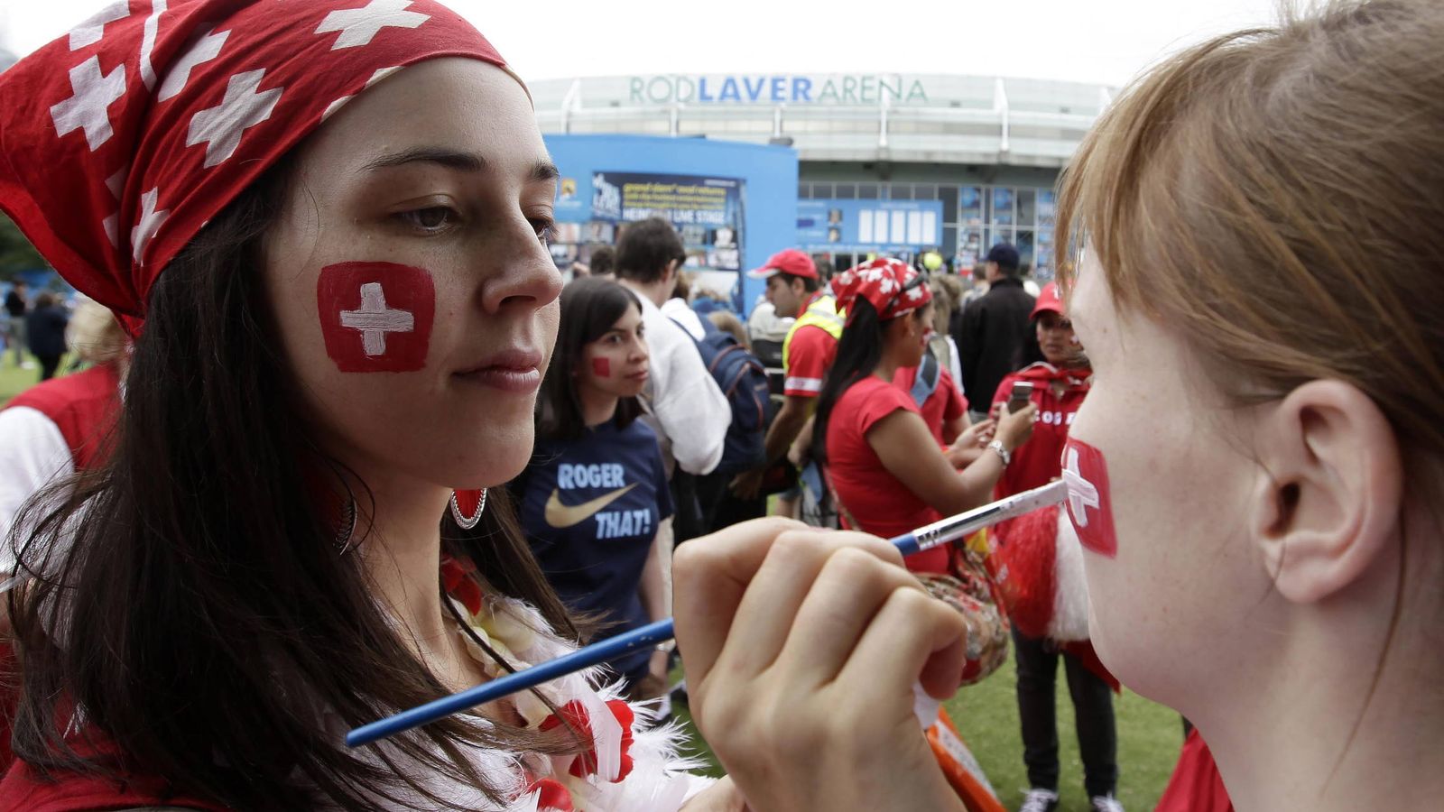 Foto: Aficionadas pintan su rostro con la bandera de Suiza. (Efe)
