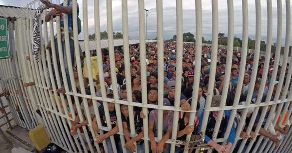Foto: Migrantes hondureños esperan acceso sobre el puente para entrar a México. (EFE)