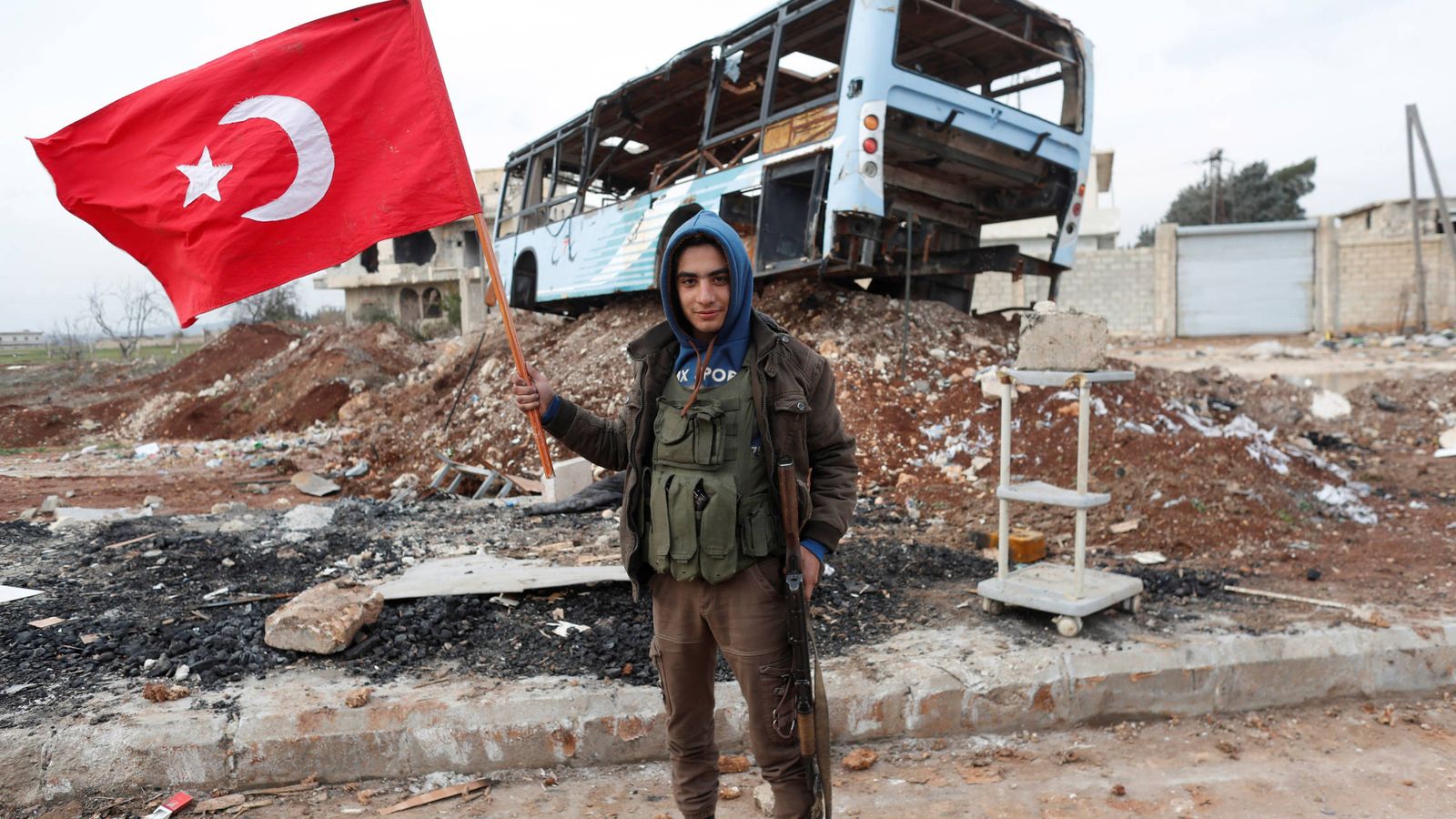 Foto: Un combatiente del Ejército Libre Sirio, apoyado por Turquía, ondea una bandera turca cerca de Azaz, Siria. (Reuters)
