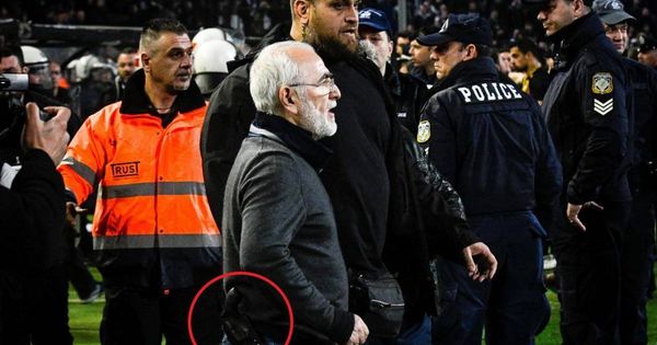Foto: El presidente y propietario del PAOK griego, Ivan Savvidis (centro), abandona el terreno de juego escoltado por sus guardaespaldas. (EFE)
